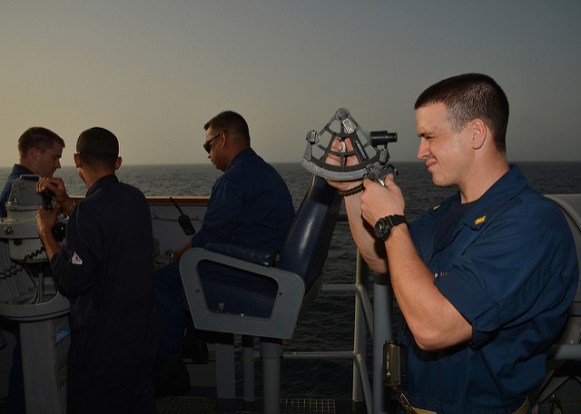 U.S. Navy officer using sextant at sea
