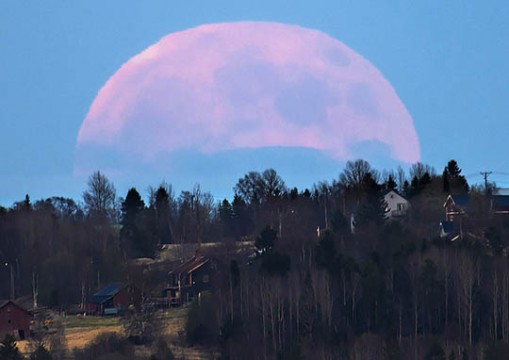 The Moon looms huge in this telephoto view taken of moonrise over the Swedish village Marieby in June 2014. Göran Strand