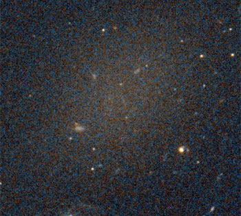 Hubble imaging picked up one of the dark galaxies. Its smattering of red stars is barely visible against the backdrop.Pieter van Dokkum & others