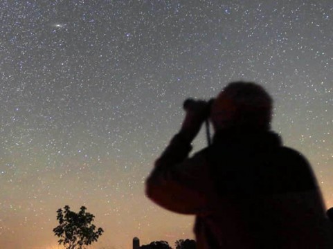 Amateur astronomer Annmarie Geniusz of Duluth, Minnesota, examines M31, the Andromeda Galaxy through 7x50 binoculars on a recent clear night.