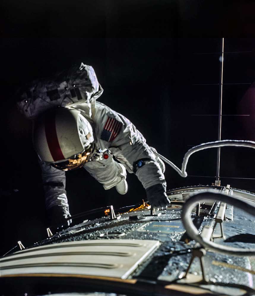 an astronaut in space works on the outside of a module