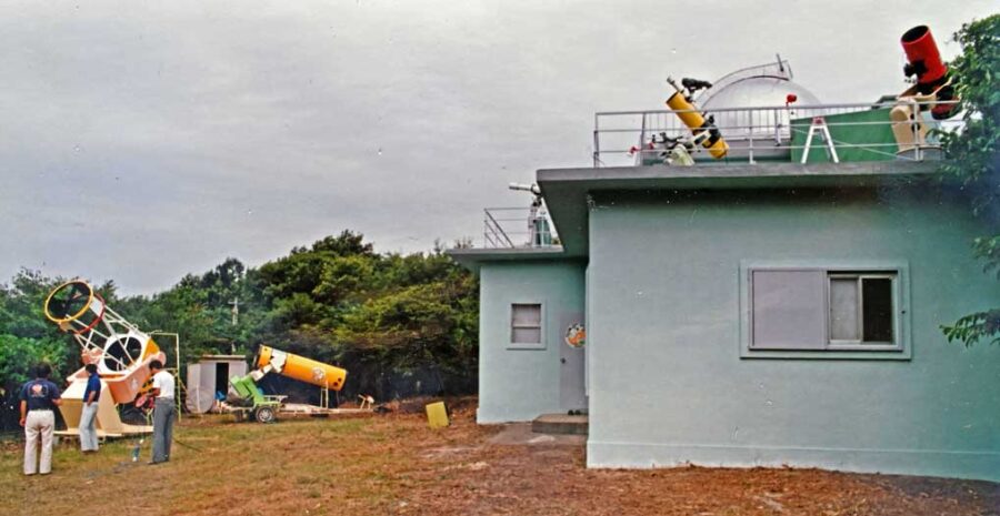 a one story building with several telescopes on top of it and several in its yard