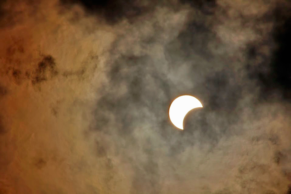 Partial solar eclipse over cloudy sky of Montreal Sky & Telescope
