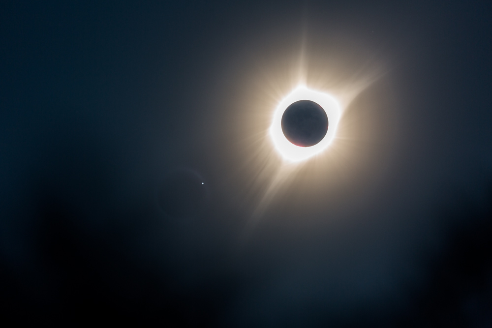 Solar Eclipse shot with an eclipse shaped solar flare peeking through