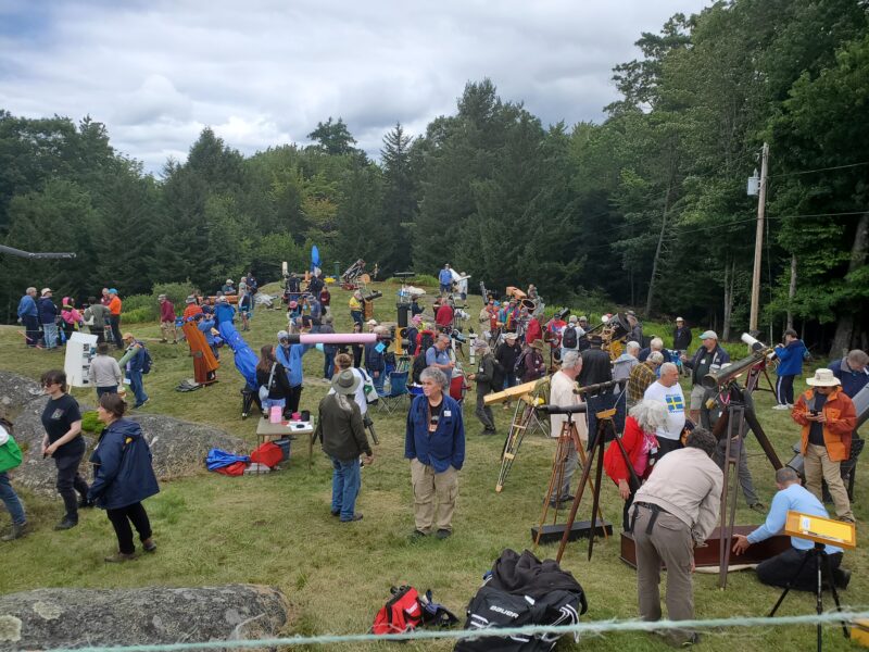 A busy field full of people and telescopes