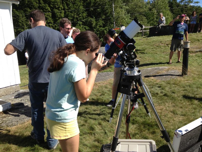 Girl looking through telescope