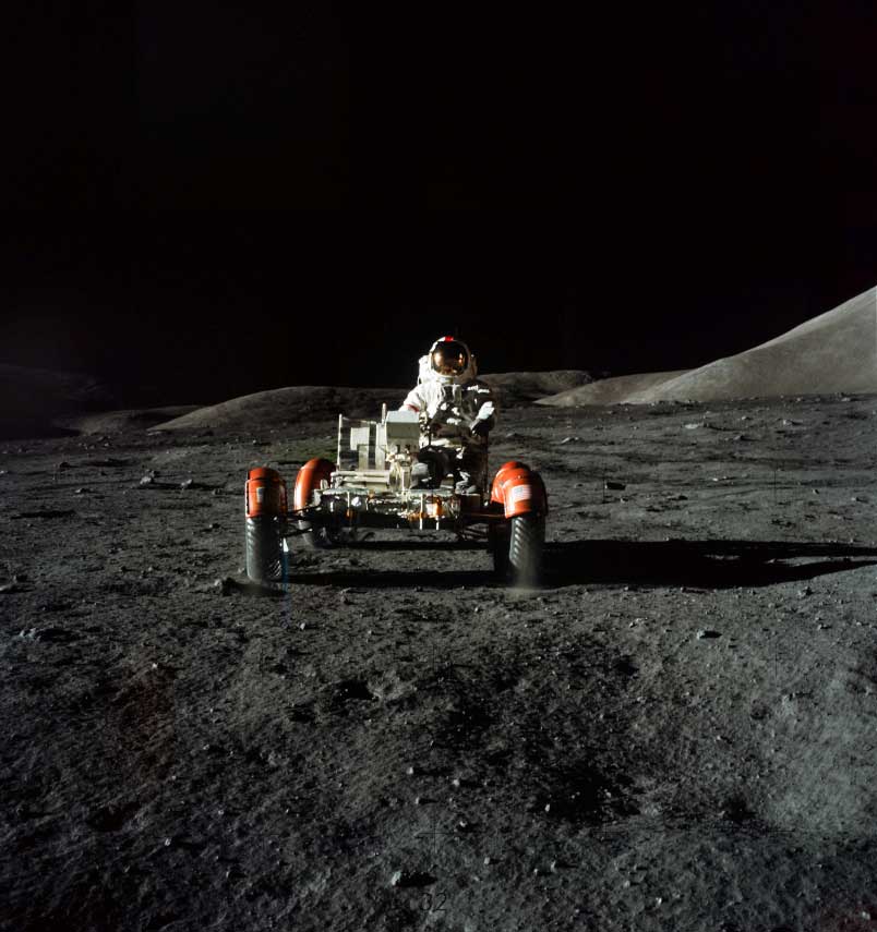 a vehicle on a dark grey moon landscape against a black background