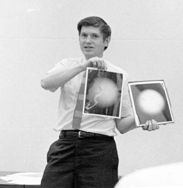 Gingerich holds up two black and white photos showing sunspots