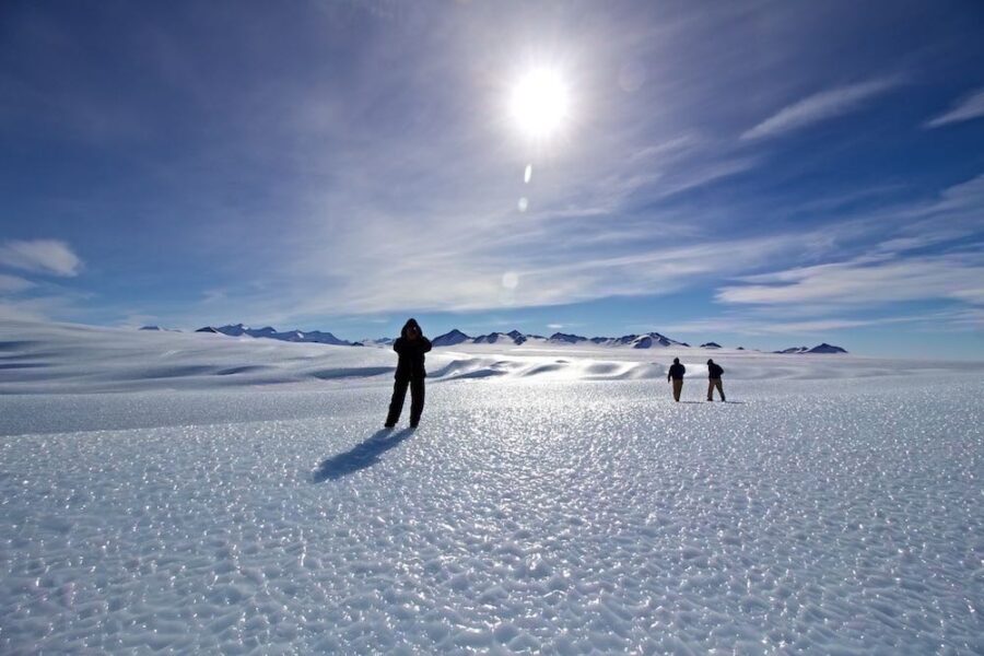 people stand on a iceberg under a bright sun