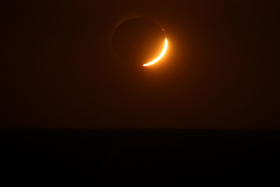 a sliver of light is visible against a dark red background