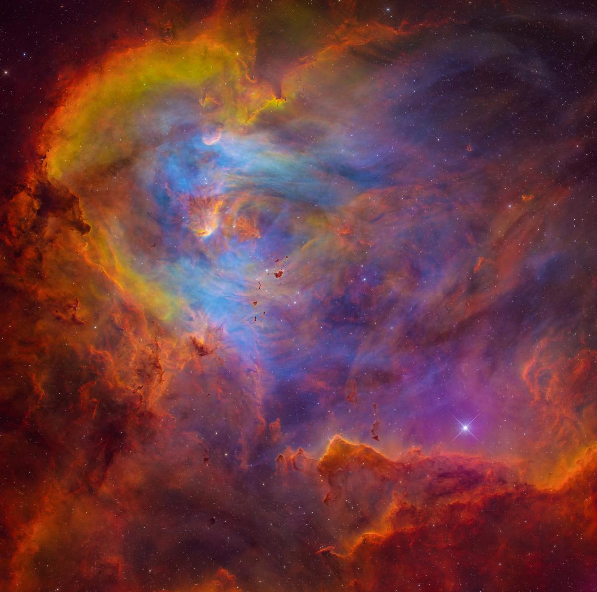 Photo of a chaotic nebula streaked with yellow, blue and orange
