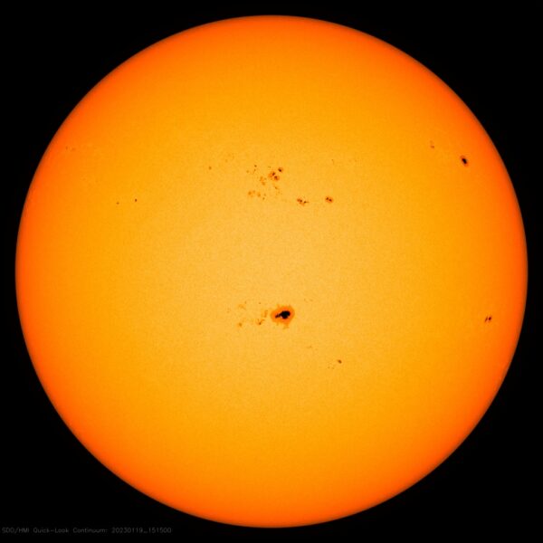 Sunspot group is black on the center of the yellow-orange disk of the Sun