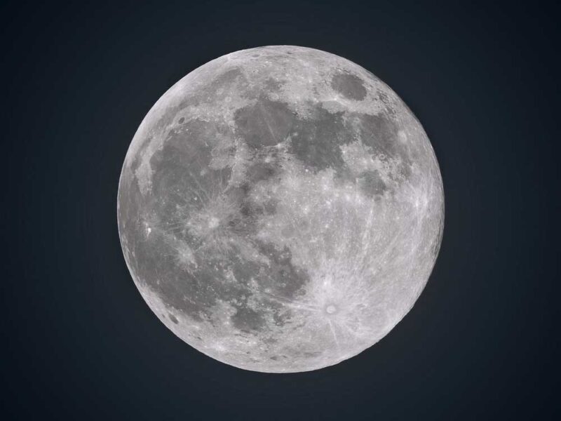 a full moon with darker grey on the left size and light grey on the right side against a black background