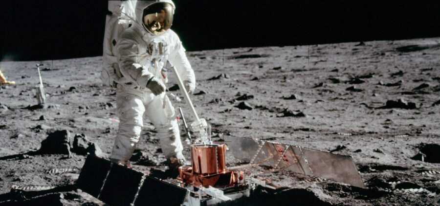An astronaut from the Apollo 11 mission deploys a seismometer on the Moon.